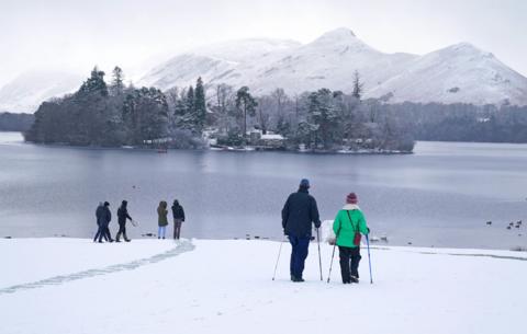 Walkers at a snowy Derwent Water