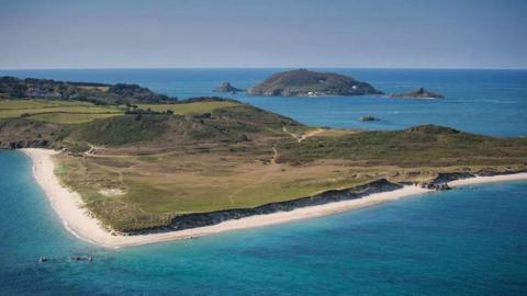 An aerial picture of Herm with Shell Beach in the foreground and Jethou in the background
