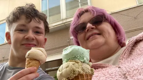 Albie Sutton Albie and Helen Sutton. They are smiling at the camera holding ice creams