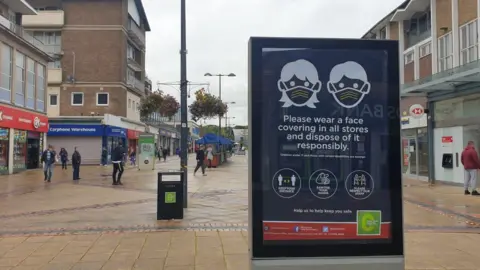 BBC Corby high street and wear a mask sign