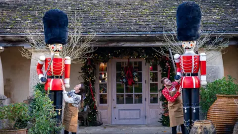 PA Media A pair of giant nutcrackers with their uniforms painted the colour of royal guardsmen in red tunics with tall black hats stand at the entrance to the function room at Highgrove
