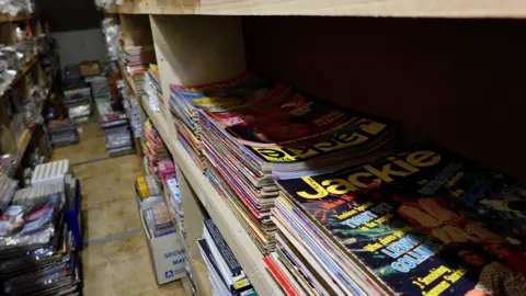 A close-up of shelves full of magazines, including editions of teen mag Jackie 