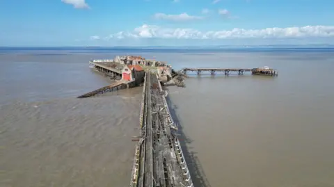 Getty Images A wide shot showing the bridge and pier in poor, crumbling condition