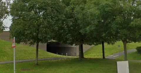 An underpass with grassy verges next to it.