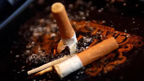 PA Media Two cigarette stubs and a used match in an ashtray