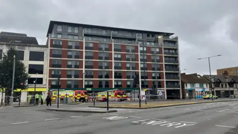 Fire engines outside an eight-storey building in High Street, Slough. The pavement infront of the building has been taped off by emergency services.