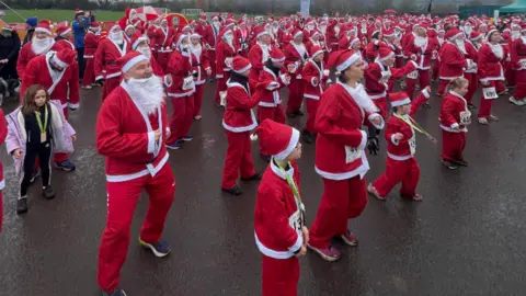 BBC People dressed in Santa costumes dancing