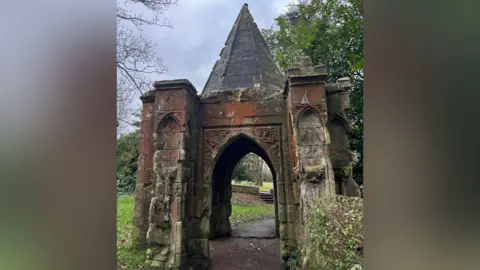 A grand stone 15th Century Porch with a cone roof.