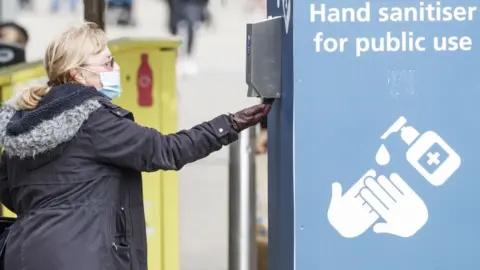 PA Media Hand sanitiser in use in Leeds