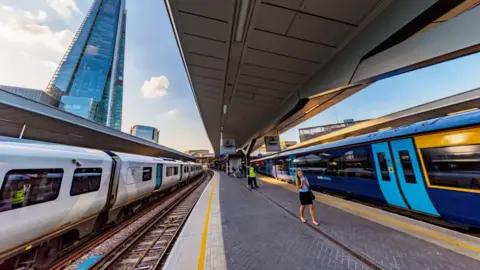 A white Thameslink and a dark blue Southeastern at London Bridge station.