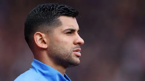 Cristian Romero looks on