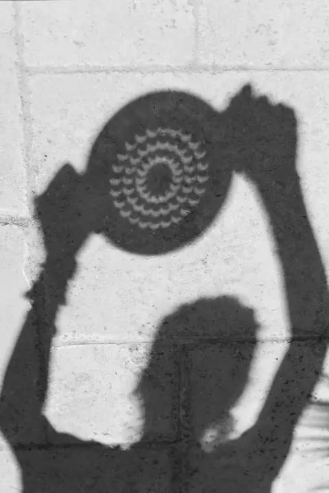 Marine Gaste Shadow of a person holding a collander