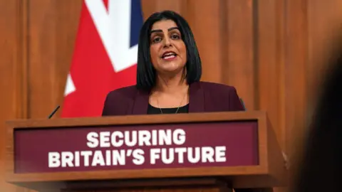 PA Media Lord Chancellor and Justice Secretary Shabana Mahmood wears a maroon blazer and stands behind a podium in Downing Street 