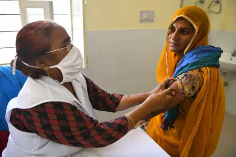Getty Images A medic administers a dose of Covaxin (COVID-19 vaccine) to a rural woman at a vaccination centre in Liri village near Beawar. Rajasthan