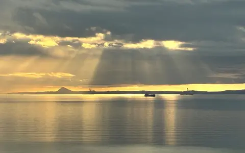 Jo Hadoke The River Forth at sunrise with rays of sun shining through the clouds