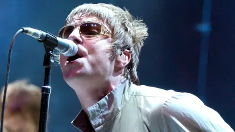 Liam Gallagher of Oasis leans into the microphone and sings