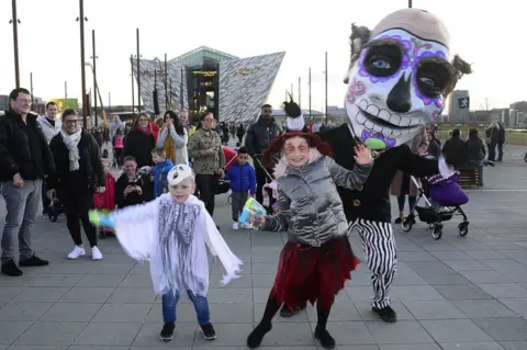 Pacemaker Children in costumes with a performer at the Halloween Monster Mash in Belfast