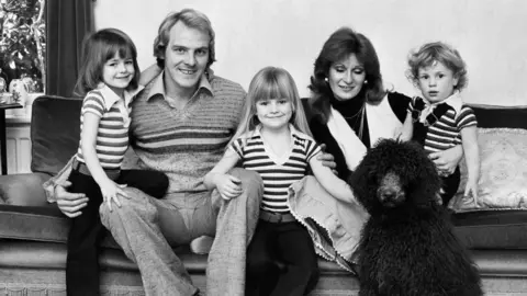 Getty Images Terry Yorath and his family in a black and white image. His wife Christine with daughters and Louise and son Daniel.