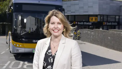 North East Combined Authority North East Mayor Kim McGuinness posing by a bus in South Shields