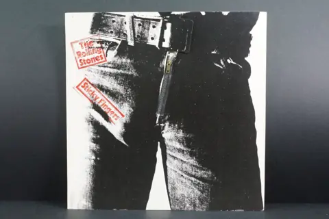 Martin Hughes Photo of an the Rolling Stones album cover. it's a black and white photo of a persons trousers and a thick belt. The album title is in red text.