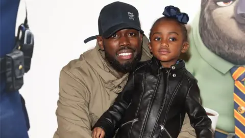 Getty Images Ghetts with his daughter at the Zootropolis premiere