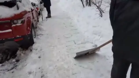 Tatyana Grigoryeva A screenshot from a video showing Moscow municipal workers scraping away the name "Navalny" from a pavement