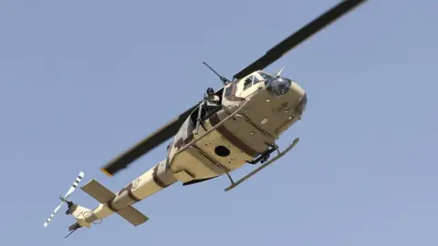 EPA A US UH-1N military helicopter hovers over the scene after six rockets were fired near Kabul airport