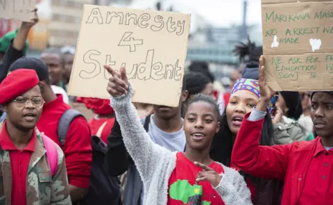 EPA Students protest, one holding a sign with the words "Amnesty 4 student", in Cape Town, South Africa - Wednesday 22 August 2018
