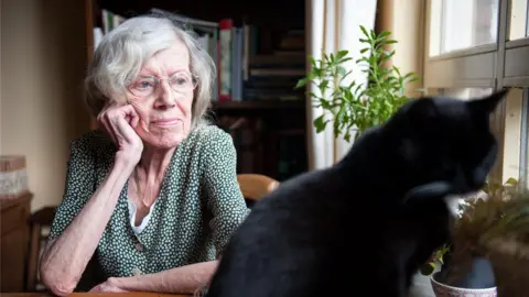 Getty Images Elderly woman looking at her cat