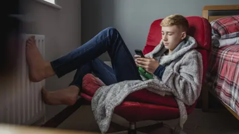 Getty Images A young man holding a phone
