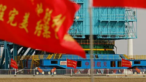 BBC/Xiqing Wang The rocket's legs are wrapped in blue scaffolding