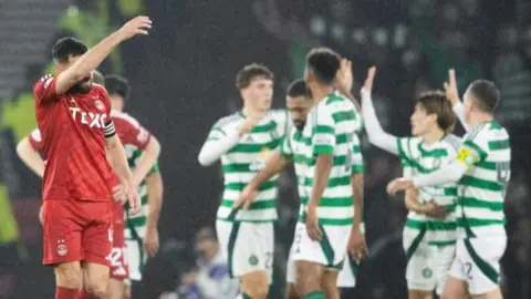 Aberdeen player looks dejected as Celtic celebrate