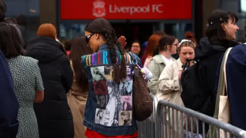 PA Media Fans queuing at the merchandise queue at Anfield Stadium