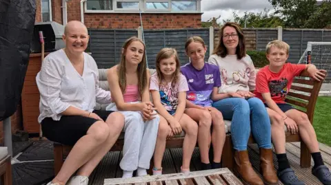 Alex Moss/BBC Debbie Holland (left) with daughters Sophie and Libby and Sarah Sykes with children Amelia and Matthew