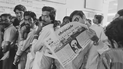 Getty Images Eleven days after a cloud from the Union Carbide plant carrying methyl isocyanate gas seriously injured 20,000 people and killed 3000, the resumption of work has been announced, provoking a new exodus. A total of 200,000 persons have fled Bhopal (which had 800,000 inhabitants). The front page of a local newspaper with a death's head. (Photo by Alain Nogues/Sygma/Sygma via Getty Images)
