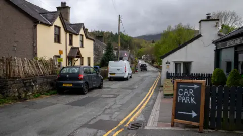 A residential street with a sign for a car park 