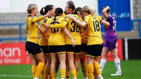 Getty Images Beth Merrick of Wolverhampton Wanderers Women celebrates with teammates after scoring a goal during the FAWNL North Premier Division match between Wolverhampton Wanderers and Loughborough Lightning at New Bucks Head Stadium on November 16, 2025 in Telford, England. (Photo by Wolverhampton Wanderers FC/Wolves via Getty Images)