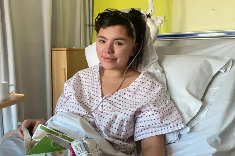 Handout Georgia in a hospital bed with a bandage on her head.