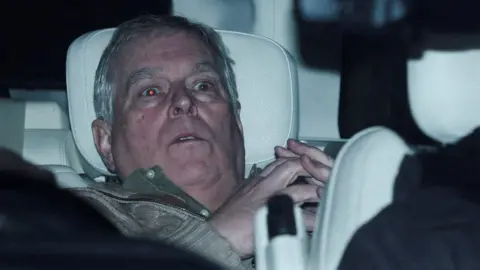 Reuters/Phil Noble A shocked Andrew leaning back on a car seat, his eyes reflecting the photographers' flashes in the red-eye effect and his hands clasped steeple-like