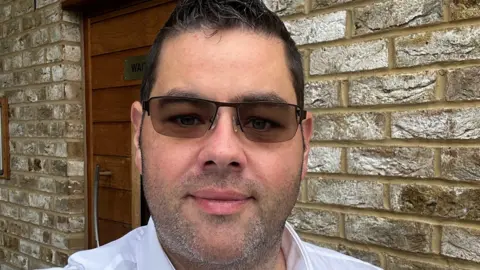 Craig Richardson Craig Richardson, wearing tinted glases, looks at the camera