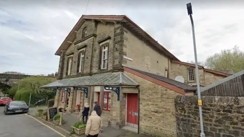 Settle Victoria Hall, a sand-coloured brick building with red doors and windows 