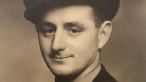 Family A black and white photo of him as a younger man in uniform and hat