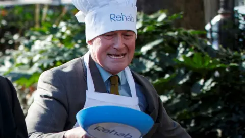 Getty Images David Amess in pancake race