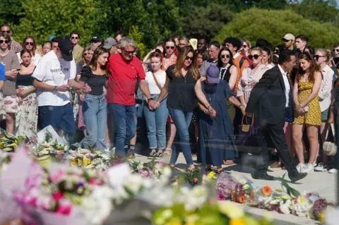 PA Media The families of Grace O'Malley-Kumar and Barnaby Webber attend a vigil at the University of Nottingham