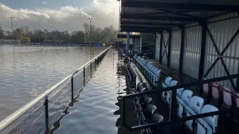 BBC A row of seats in a metal shed at Lydney Town football club's pitch, which is totally flooded