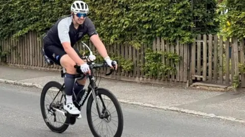 Man in cycling gear and helmet on a bike