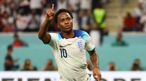 Raheem Sterling points one finger in the air as he celebrates scoring a goal for England