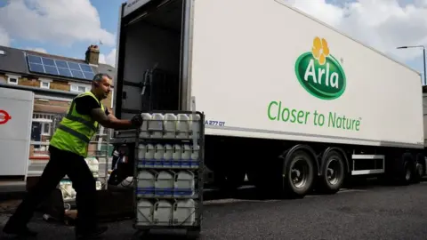 Getty Images A lorry driver for Arla Foods makes a milk delivery