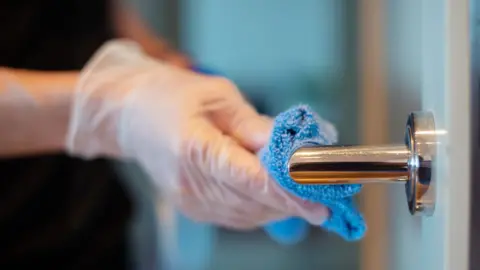 Getty Images hand wiping door handle