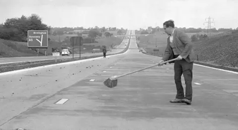 Man brushing M1 motorway in 1959